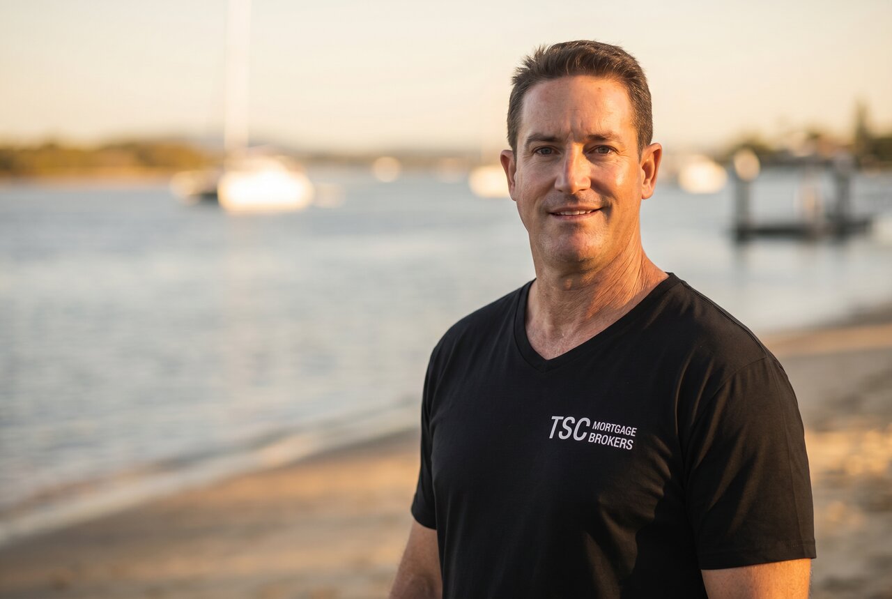 Mathew Punter, founder of Flip 360, on the Sunshine Coast waterfront — TSC Mortgage Brokers shirt, late afternoon light